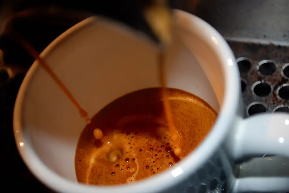 Double espresso streaming into a cup