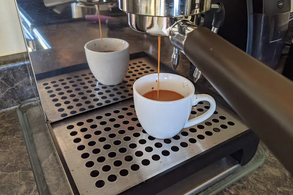 Espresso pouring from a bottomless portafilter into a cup