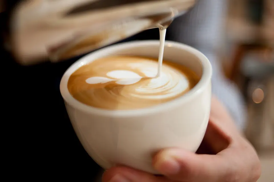 Steamed milk being poured into a latte
